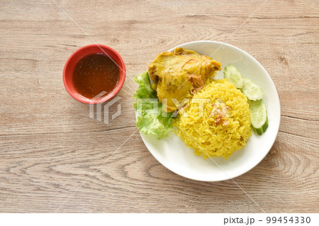 biryani rice cooked with chicken in curry on plate dipping spicy chili sauce 99454330