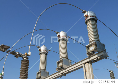 Part of high-voltage substation on blue sky background with switches and disconnectors. Ukrainian energy infrastructure. 99456144
