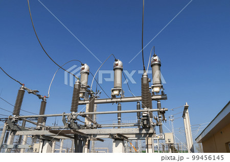 Part of high-voltage substation on blue sky background with switches and disconnectors. Ukrainian energy infrastructure. 99456145