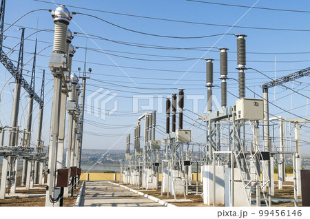Part of high-voltage substation on blue sky background with switches and disconnectors. Ukrainian energy infrastructure. Part of high-voltage substation on blue sky background with switches and disconnectors. Ukrainian energy infrastructure. 99456146