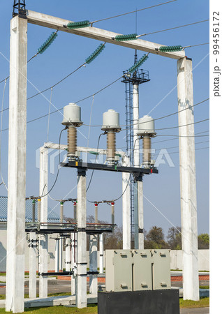 Part of high-voltage substation on blue sky background with switches and disconnectors. Ukrainian energy infrastructure. Part of high-voltage substation on blue sky background with switches and disconnectors. Ukrainian energy infrastructure. 99456172