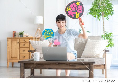 推し活 ライブ動画を見ながらうちわを振って推しを応援するz世代の女の子 推し活 ライブ動画を見ながらうちわを振って推しを応援するz世代の女の子 99456402