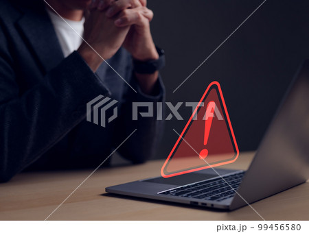 Computer notification error maintenance concept. Businessman or personnel, programmer, or developer using a computer laptop with a triangle warning exclamation red sign trouble caution. 99456580