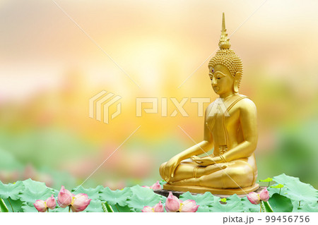 Makha Asanaha Visakha Bucha Day Golden Buddha image. Background of Bodhi leaves with shining light. Soft image and smooth focus style 99456756