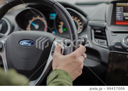 Ukraine - 01.26.2023: Man driving car Ford Fiesta. Auto interior. Man hand on steering wheel. Auto dashboard. Journey concept. Personal transport. Inside the car. Speed background. Driver in car. Ukraine - 01.26.2023: Man driving car Ford Fiesta. Auto interior. Man hand on steering wheel. Auto dashboard. Journey concept. Personal transport. Inside the car. Speed background. Driver in car. 99457006