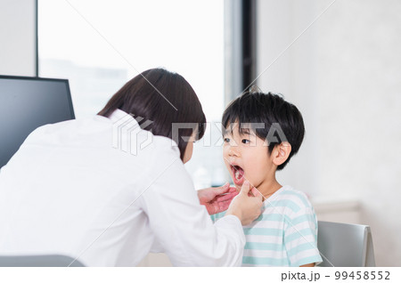 女性医師の診察を受ける男の子 99458552