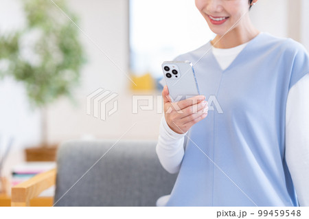 リビングでスマートフォンを操作する女性(パーツ) リビングでスマートフォンを操作する女性(パーツ) 99459548