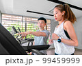 young happy asian woman athlete run on treadmill, running machine, in indoor gym fitness for health; 99459999