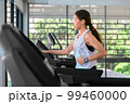 young happy asian woman athlete run on treadmill, running machine, in indoor gym fitness for health; 99460000