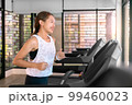 young happy asian woman athlete run on treadmill, running machine, in indoor gym fitness for health; 99460023