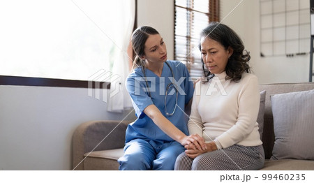 Female doctor holding female patient hands with compassion and comfort for encouragement and empathy 99460235