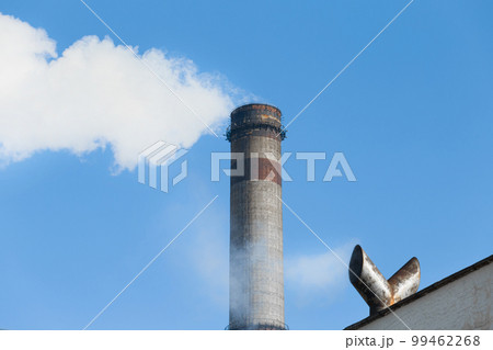Pollution of the environment, atmosphere, air, environmental problems. Smoke is emitted from the industrial steam pipe of the plant opposite the cooling tower for cooling hot water in steam plants Pollution of the environment, atmosphere, air, environmental problems. Smoke is emitted from the industrial steam pipe of the plant opposite the cooling tower for cooling hot water in steam plants 99462268