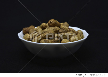 Groundnut. Unpeeled peanuts in a white plate. Peanuts in the peel. Groundnut. Unpeeled peanuts in a white plate. Peanuts in the peel. 99463392