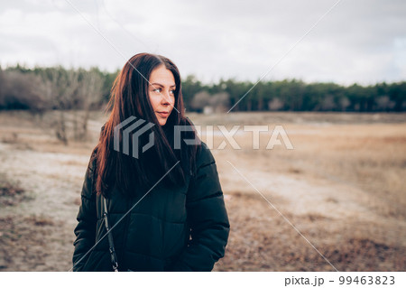 Portrait of young smiling brunette woman in winter jacket looking at camera Portrait of young smiling brunette woman in winter jacket looking at camera 99463823