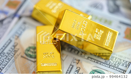 Close-up yellow gold ingots lie on money Close-up yellow gold ingots lie on money 99464132