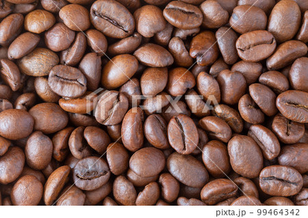 Roasted coffee beans background, top view macro, Coffea. 99464342