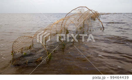 fishing net a fish-trap on lake fishing net a fish-trap on lake 99464439