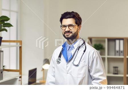 Smiling man is doctor in his office of modern medical institution. 99464871