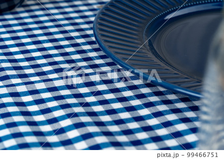 Classic blue ceramic tableware on checkered tablecloth 99466751