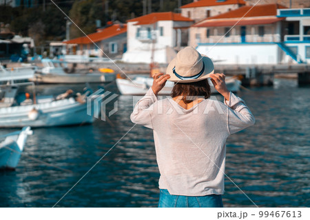 Girl in a hat travels, enjoys beautiful views on the seashore. Girl in a hat travels, enjoys beautiful views on the seashore. 99467613