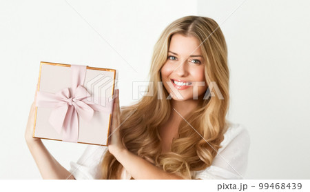 Holiday present for birthday, baby shower, wedding or luxury beauty box subscription delivery, happy woman holding a wrapped pink gift on white background Holiday present for birthday, baby shower, wedding or luxury beauty box subscription delivery, happy woman holding a wrapped pink gift on white background 99468439