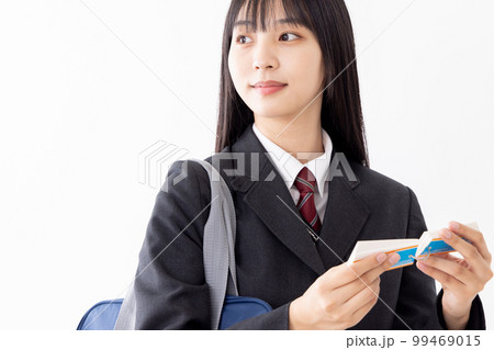通学中に効率よく単語帳で勉強をする女子高生 通学中に効率よく単語帳で勉強をする女子高生 99469015