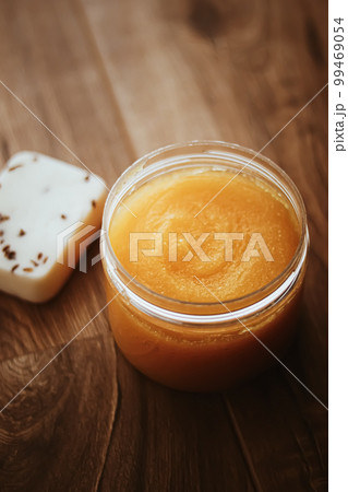 Citrus and honey orange body scrub jar on rustic wood background, beauty cosmetic and skincare product. Citrus and honey orange body scrub jar on rustic wood background, beauty cosmetic and skincare product. 99469054