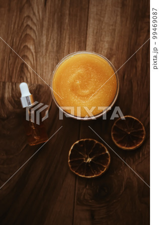 Citrus and honey orange body scrub jar on rustic wood background, beauty cosmetic and skincare product. 99469087