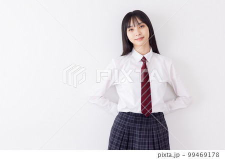 白壁によりかかる女子高生 99469178