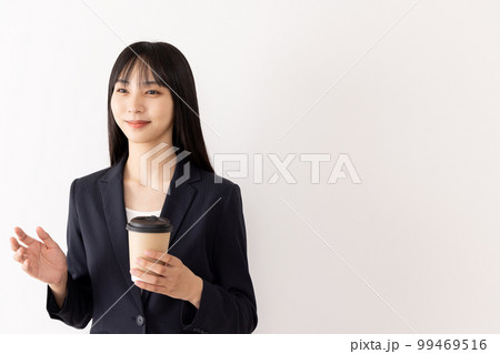 コーヒーを飲みながら会話をするビジネスウーマン 99469516