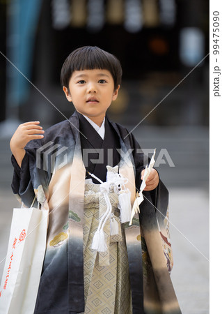 和服で七五三のお宮参りに来た5歳男児が神社の境内で扇子片手に