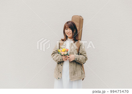 ギターと花束を持った女性の写真 99475470