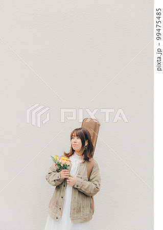 ギターと花束を持った女性の写真 ギターと花束を持った女性の写真 99475485
