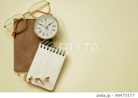 Notepad, diary, clock, eyeglasses on yellow desk background. flay lay, top view, copy space 99475577