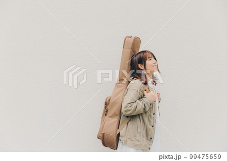 ギターと花束を持った女性の写真 ギターと花束を持った女性の写真 99475659