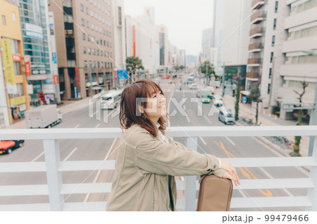 街バックのギターを持った女性の写真 99479466