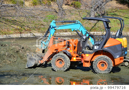 水が抜かれた池に降ろされた重機 99479716