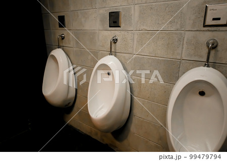 Dismal men's restroom urinals with a prison feel 99479794