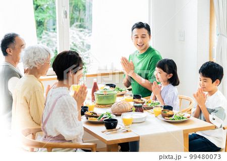 食事をする三世代家族 99480073