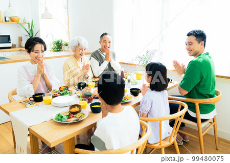 食事をする三世代家族 99480075