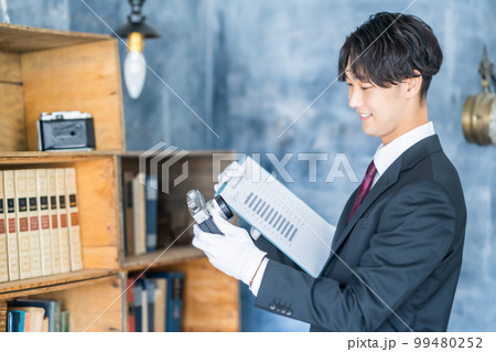 出張買取でカメラを手にする男性鑑定士 出張買取でカメラを手にする男性鑑定士 99480252