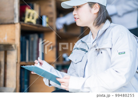 棚の確認をする女性の不用品回収業者 99480255