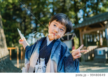 和服姿で七五三のお宮参りに来た5歳児が神社の境内でややおどけ気味に