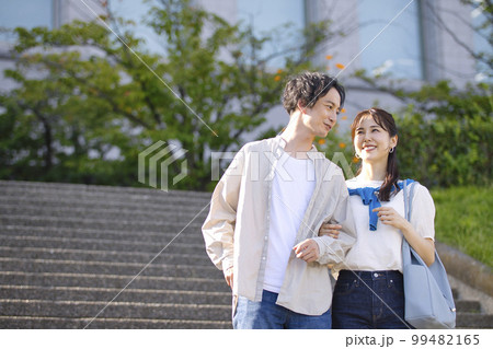 腕を組んで散歩する若いカップル 99482165
