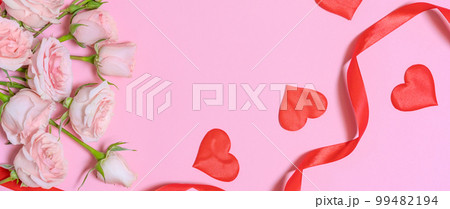 Lace ribbon and hearts and pink rose flowers on a pink background. Happy 99482194
