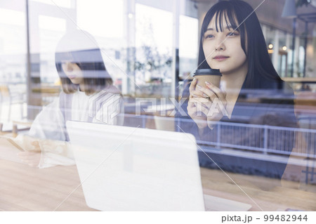 カフェでお茶をする若いビジネスウーマン カフェでお茶をする若いビジネスウーマン 99482944