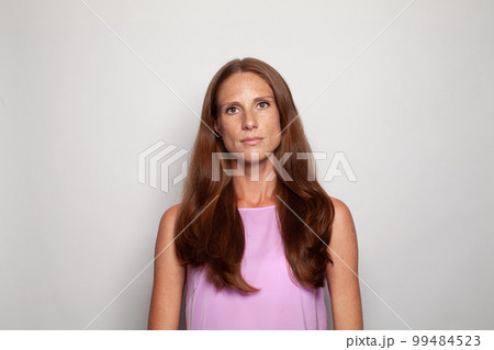 Real woman portrait. Mature woman with long brown hair on white background 99484523