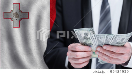 Hands holding dollar money on flag of Malta 99484939