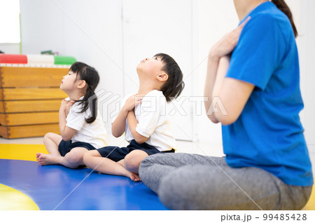 室内で運動をする子供たちと先生 ストレッチ 99485428