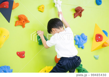 体操クラブなどでボルダリングをする子供	 99485430